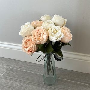 Milk jar filled with fake pink and white roses.